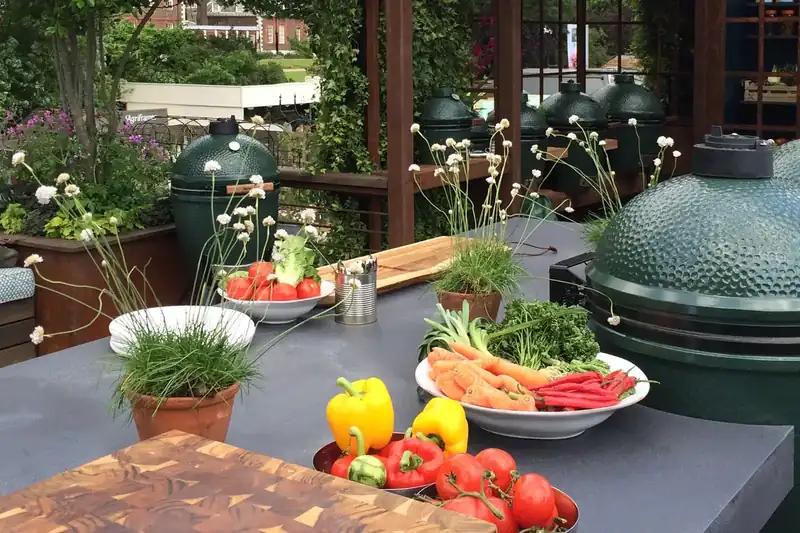 Outdoor kitchen with a Big Green Egg set into a concrete counter in a garden