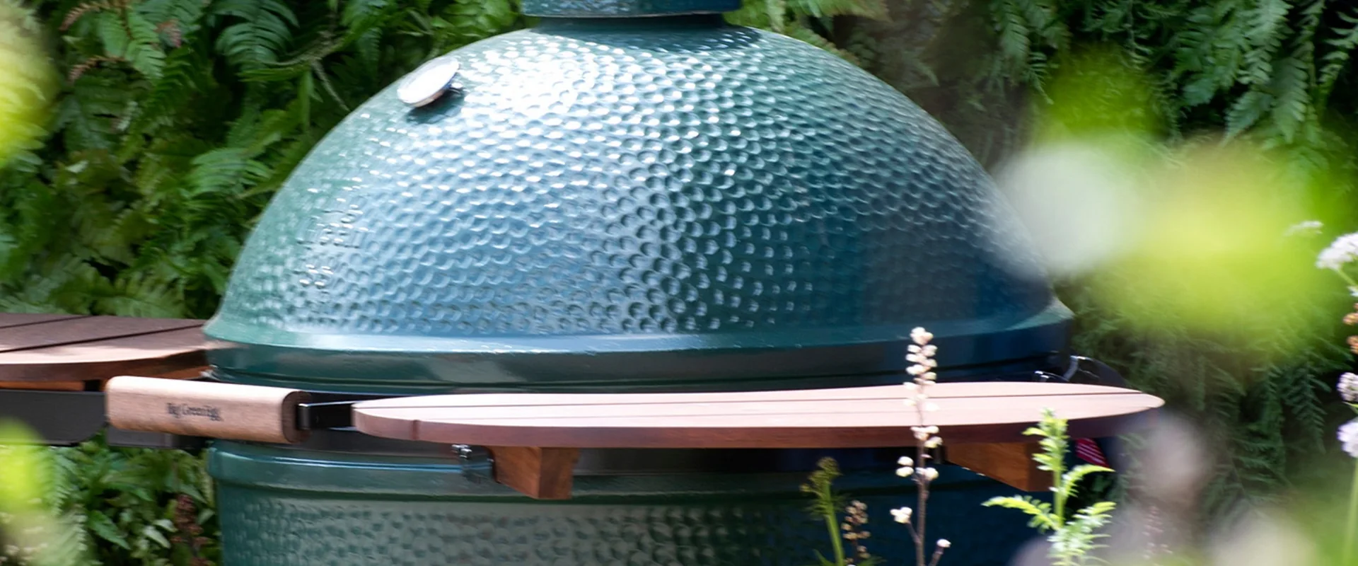 Big Green Egg XLarge kamado in a mahogany table nest in a garden