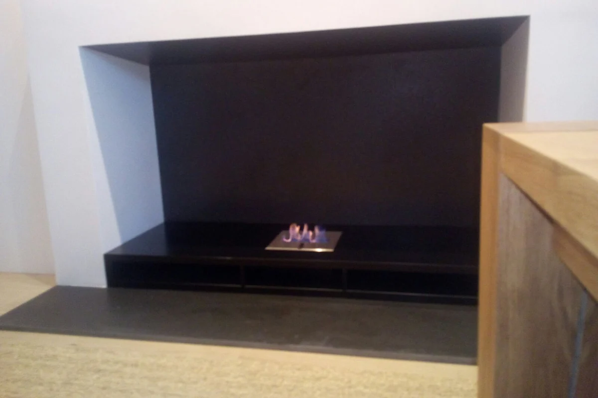 EcoSmart bioethanol burner on the black hearth of a converted masonry fireplace with a timber surround