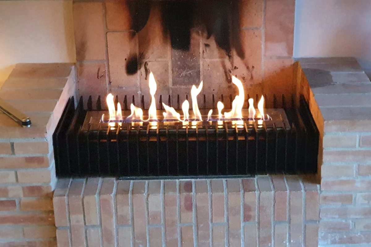 EcoSmart bioethanol burner with a black grate set into a converted brick wood-burning fireplace