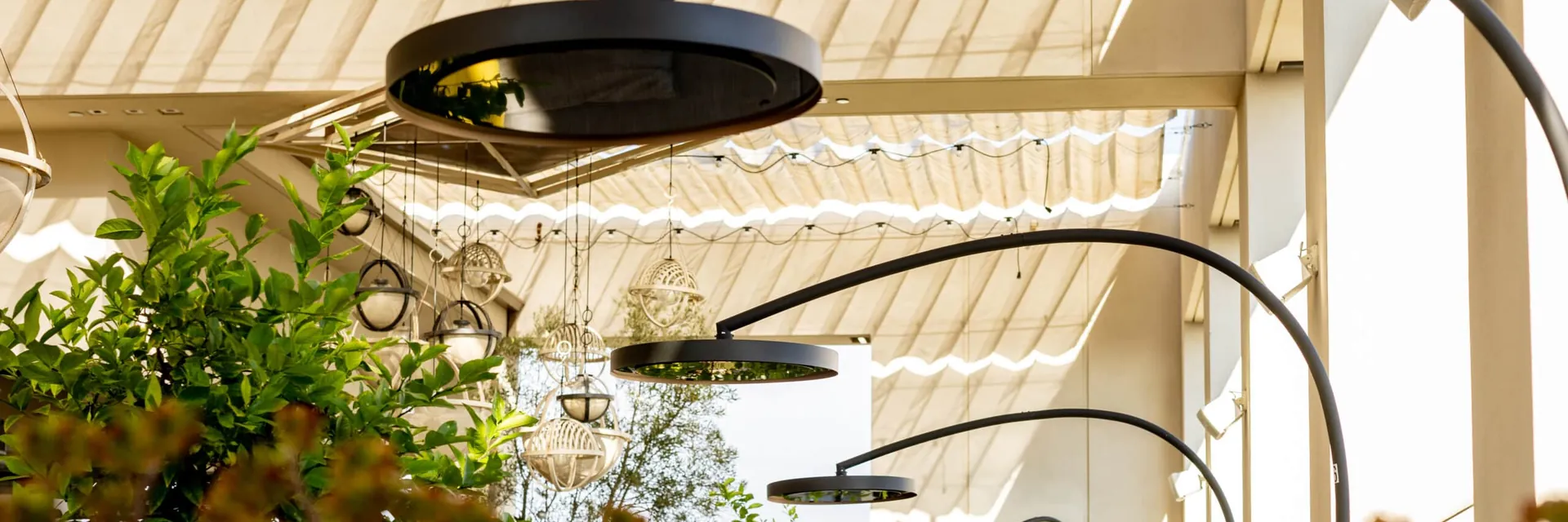 Bromic Eclipse Smart-Heat Portable heaters with curved arms beside a dining table on a terrace with plants