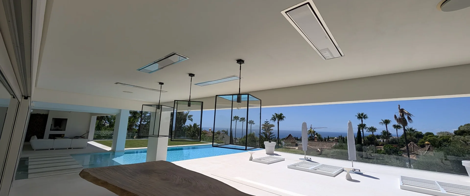 Covered terrace of a villa in Sierra Blanca, Marbella, with Bromic infrared heaters, a pool and views over the coast