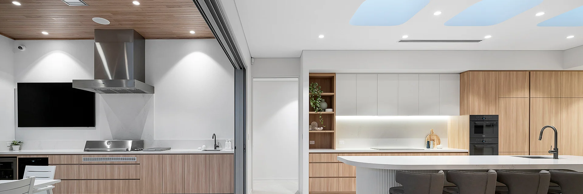 Bromic Platinum Smart-Heat Electric heaters recessed in the ceiling of an open-plan kitchen and dining space that opens to a terrace