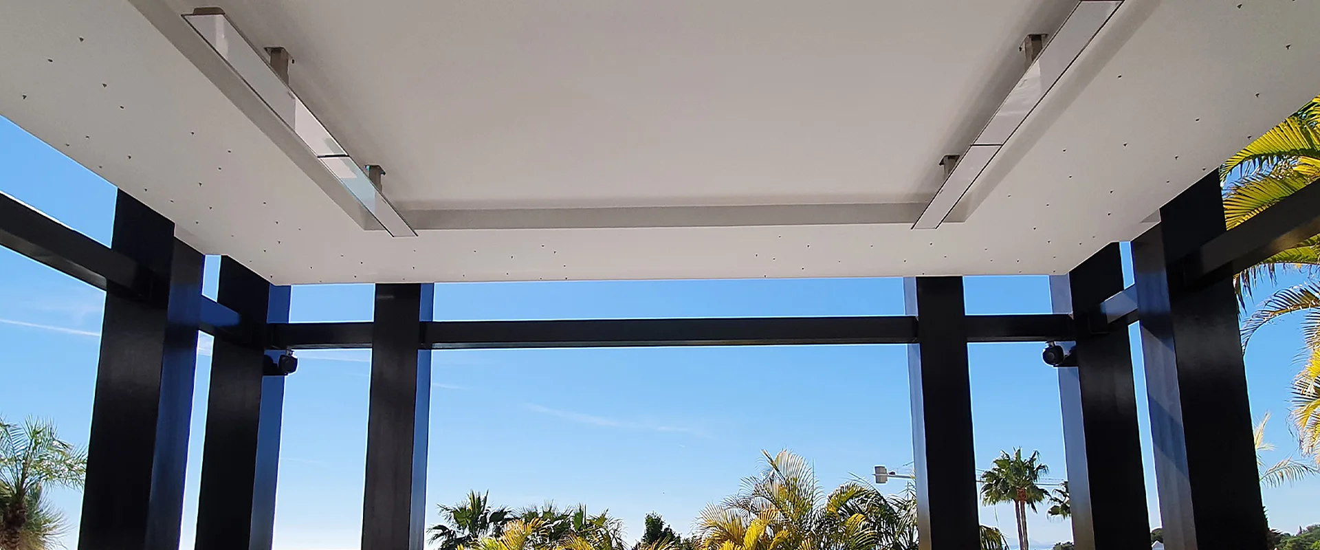 White Bromic Platinum heaters set into the ceiling of an open pavilion with a sunken lounge and sea views, Marbella