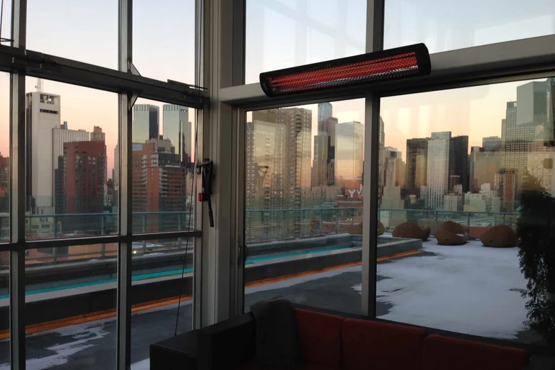 Bromic Tungsten Smart-Heat Electric heater mounted above the glazing of a rooftop lounge with a city view