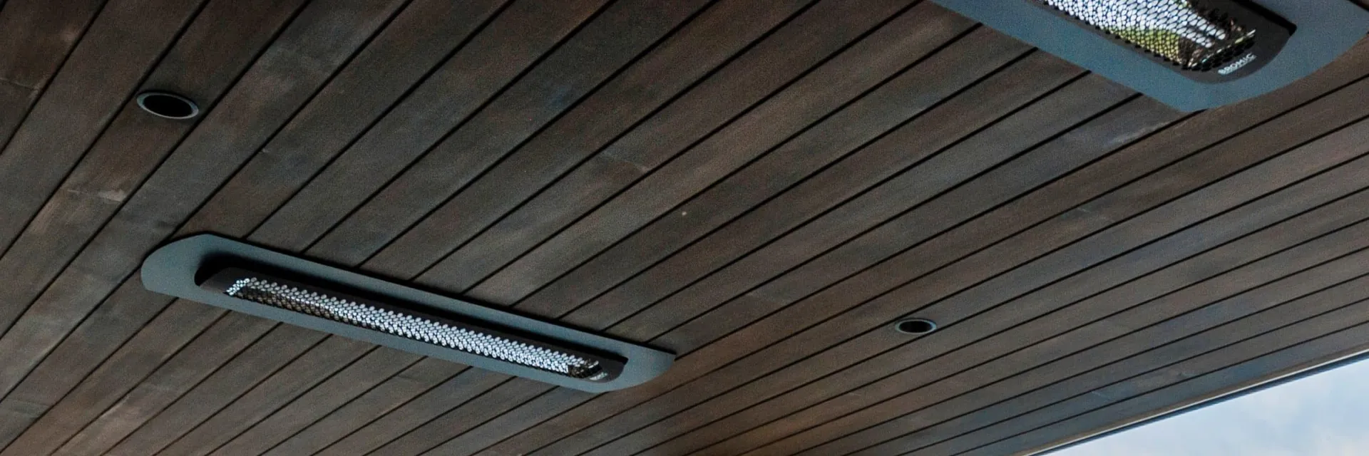 Bromic Tungsten Smart-Heat Electric heaters mounted in the timber ceiling of a terrace overlooking the water