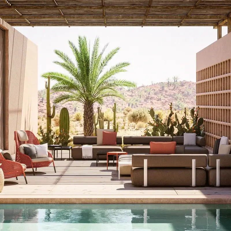 Dedon Brixx modular sofa with red accent chairs in a courtyard with a palm tree, a pool and desert hills