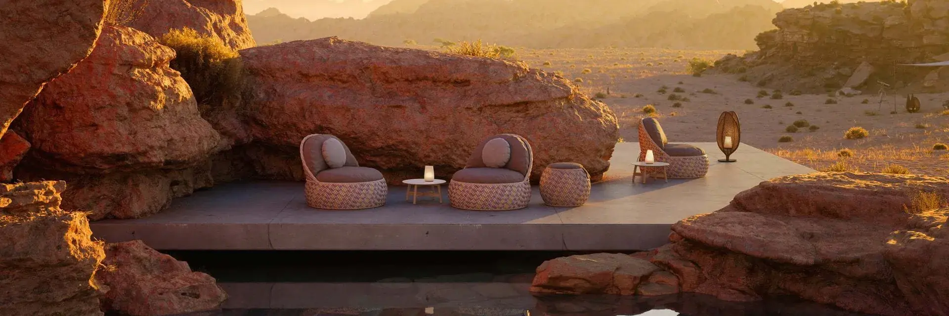 Dedon Dala lounge chairs on a platform among red desert rocks at dusk, with mountains on the horizon