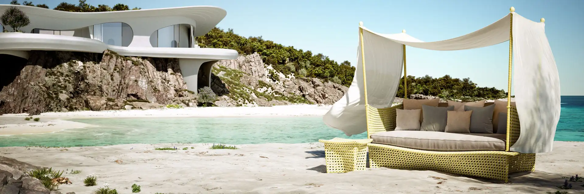 Dedon Daydream four-poster daybed with a white canopy on pale sand beside a turquoise lagoon, with a curved white house on the rocks behind