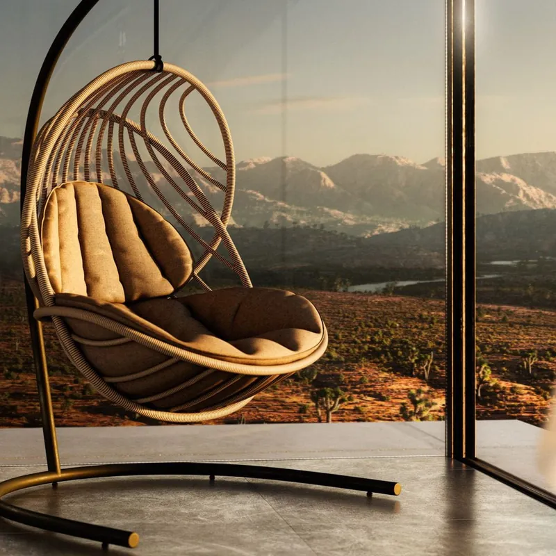 Dedon Kida hanging lounge chair on its stand with brown cushions, on a terrace with a mountain view