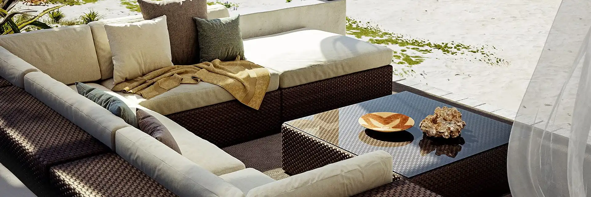 Dedon Lounge modular sofa with white cushions on a beach deck with white curtains, beside the sea