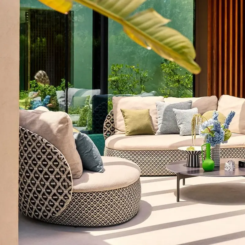 Dedon Mdear lounge chair and sofa with patterned weave and soft cushions on a shaded terrace
