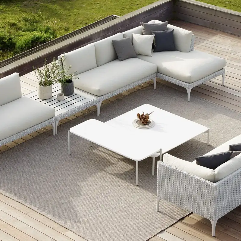 Dedon Mu modular sofa in white with a low table on a wooden deck, seen from above