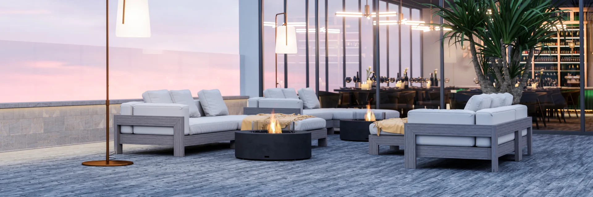 EcoSmart Ark 40 fire table between outdoor sofas on the terrace of a modern villa at dusk
