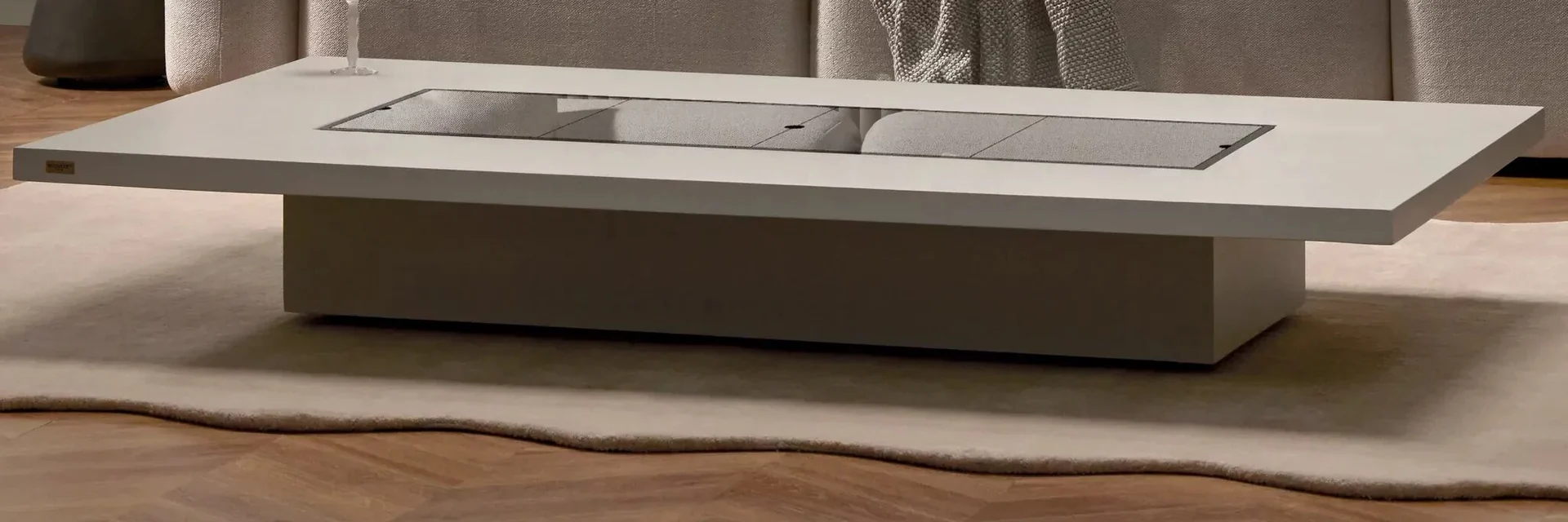 Long EcoSmart Daiquiri 70 fire table with a glass cover plate in front of a pale sofa in a living room