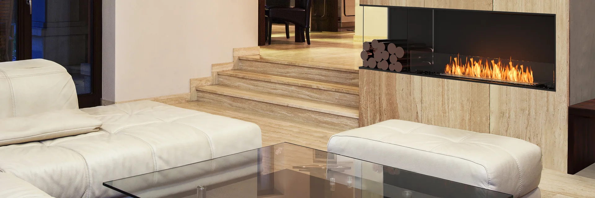 EcoSmart Fire Flex corner fireplace burning in a timber-clad wall above white sofas and a glass coffee table