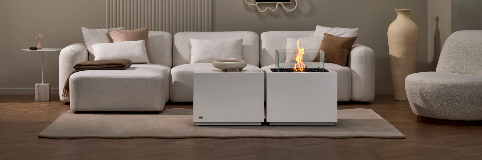 EcoSmart Sidecar 24 fire table in white burning in front of a white modular sofa in a living room with pale walls