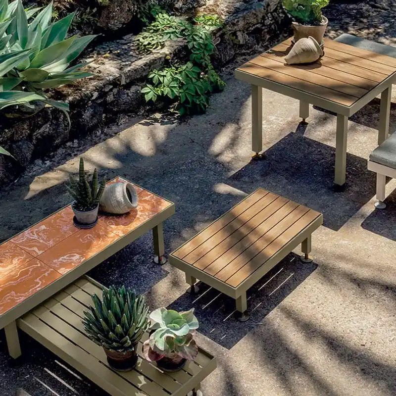 Ethimo Seeds teak benches and tables holding potted succulents on a paved garden terrace, seen from above