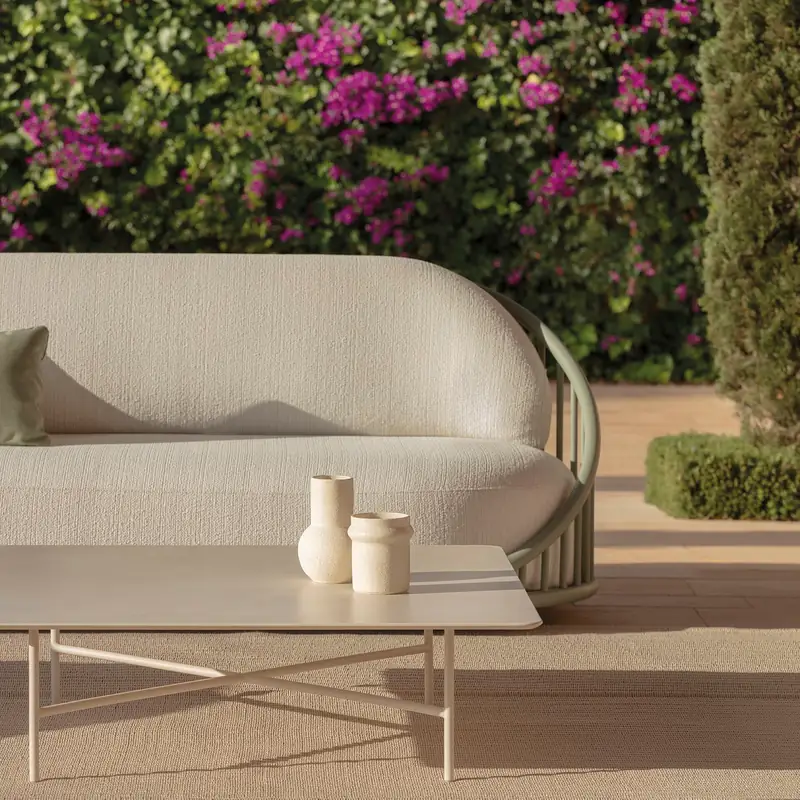 Expormim Cask sofa with a rope-wrapped base and a slim coffee table in front of a wall of pink bougainvillea