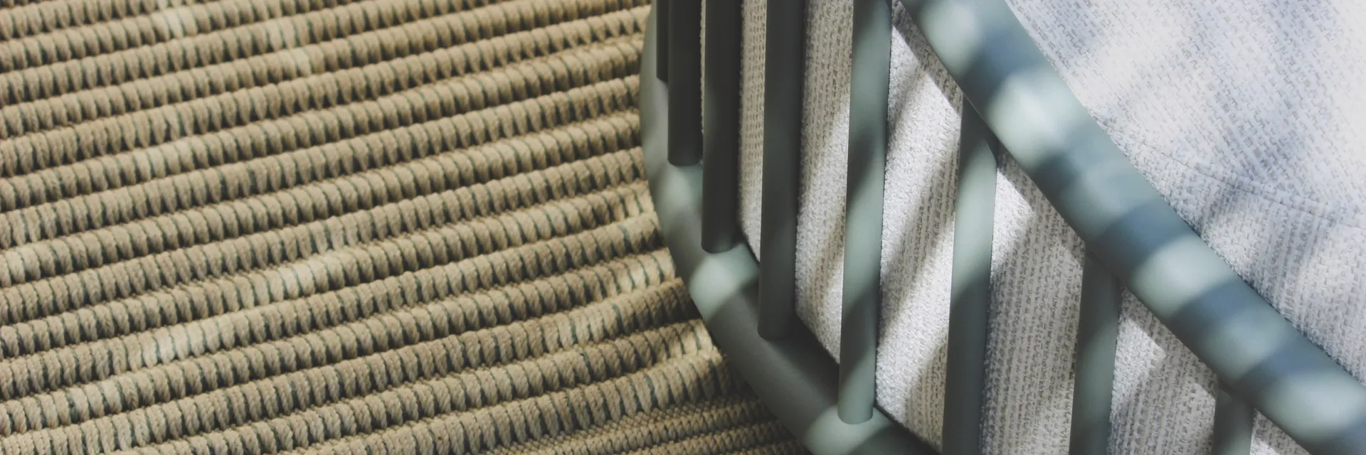 Close view of the woven rope and green slatted frame of an Expormim Cask seat in dappled light
