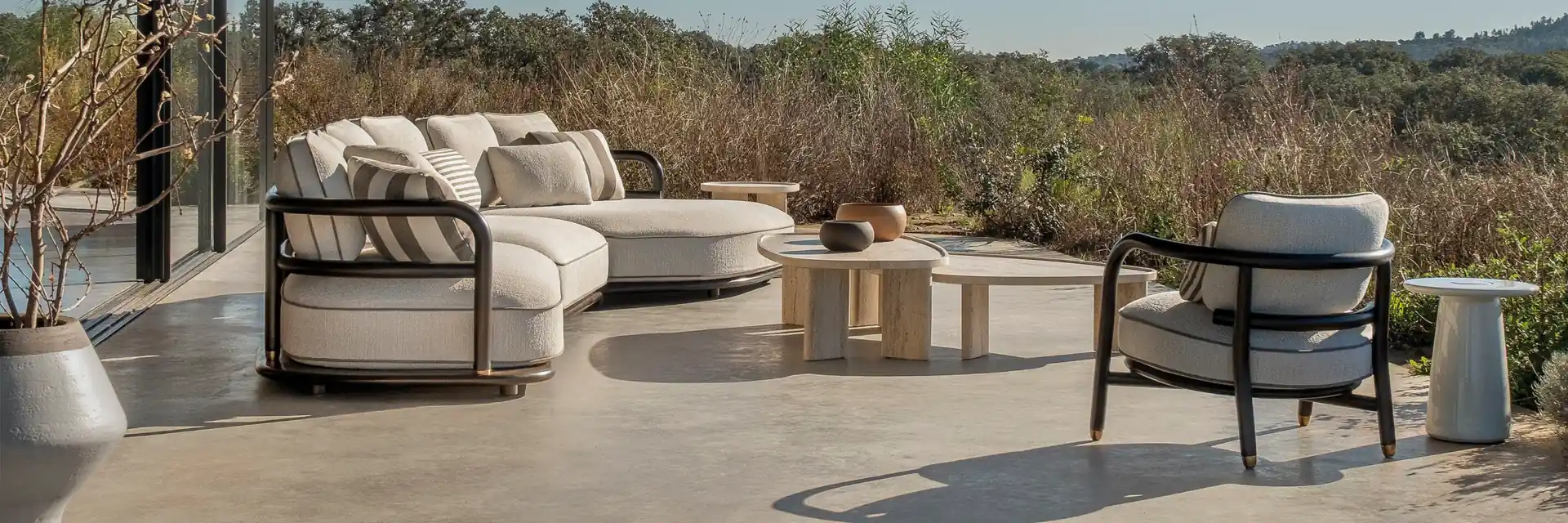 Expormim Meridies sofa and armchair on a terrace under a concrete canopy, overlooking scrubland hills