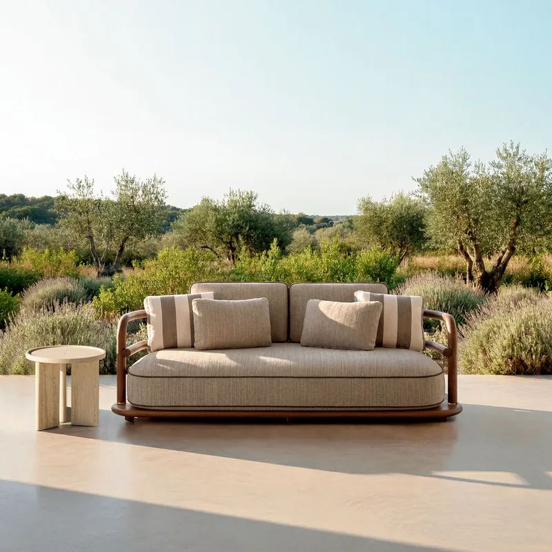 Expormim Meridies sofa with a wooden frame and cream cushions on a stone terrace, olive trees and scrubland behind