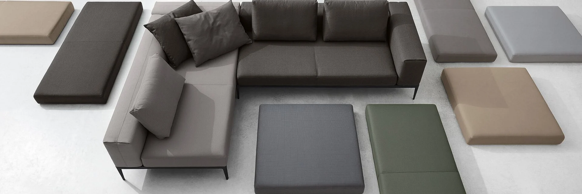 Gloster Grid modular sofa seen from above, with loose seat cushions in grey, green and terracotta laid out around it