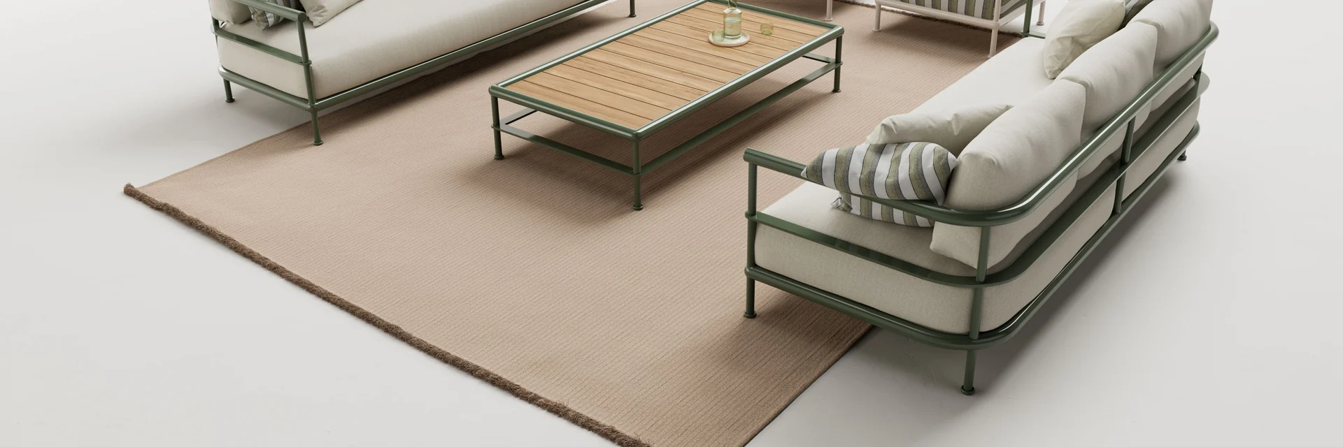 Kettal Alize sofas, armchairs and a teak-topped coffee table arranged on a rug, seen from above against a pale studio backdrop