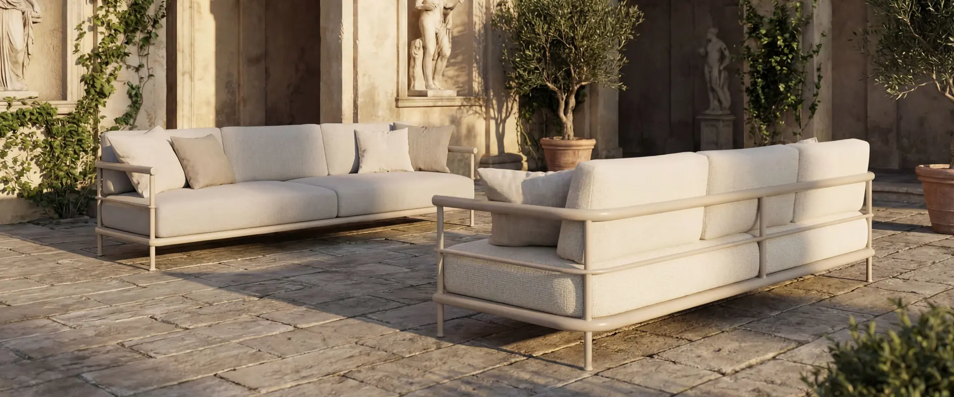 Kettal Alize modular sofas in cream fabric on the stone paving of an Italian villa courtyard with arches and climbing plants