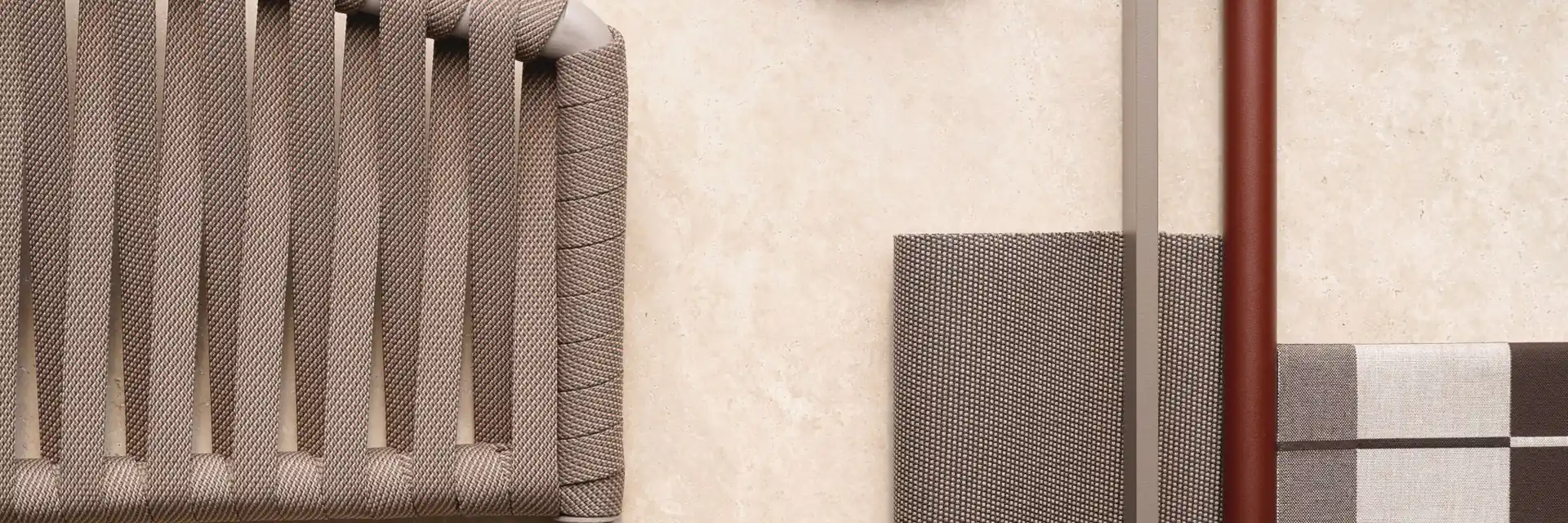 Flat lay of Kettal Bitta materials: braided rope, an aluminium frame section, fabric samples and a stone disc