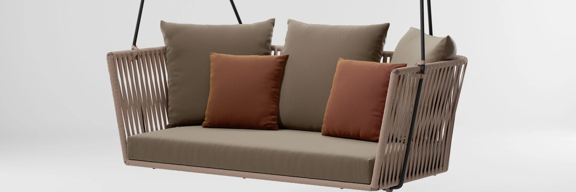 Kettal Bitta swing sofa with a braided-rope frame and terracotta cushions, hanging against a pale studio backdrop