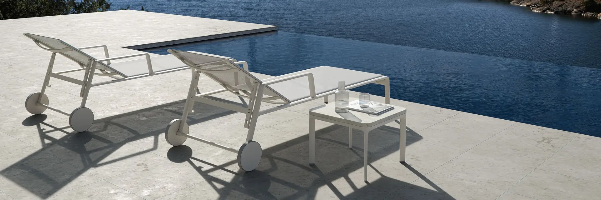 Kettal Park Life sun loungers on a terrace above a calm inlet with wooded islands
