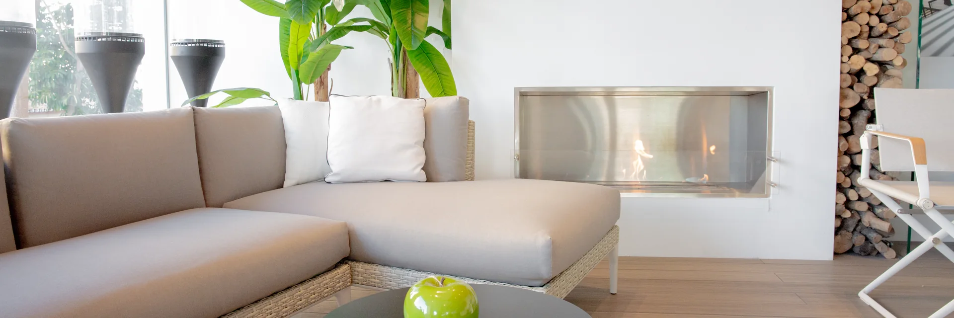Corner outdoor sofa in front of a built-in bioethanol fireplace in the Outdoor Concepts showroom