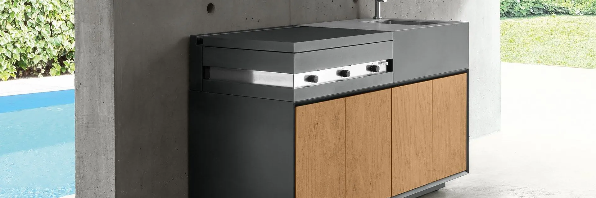 Talenti Tikal outdoor kitchen module with timber fronts under a concrete canopy beside a pool