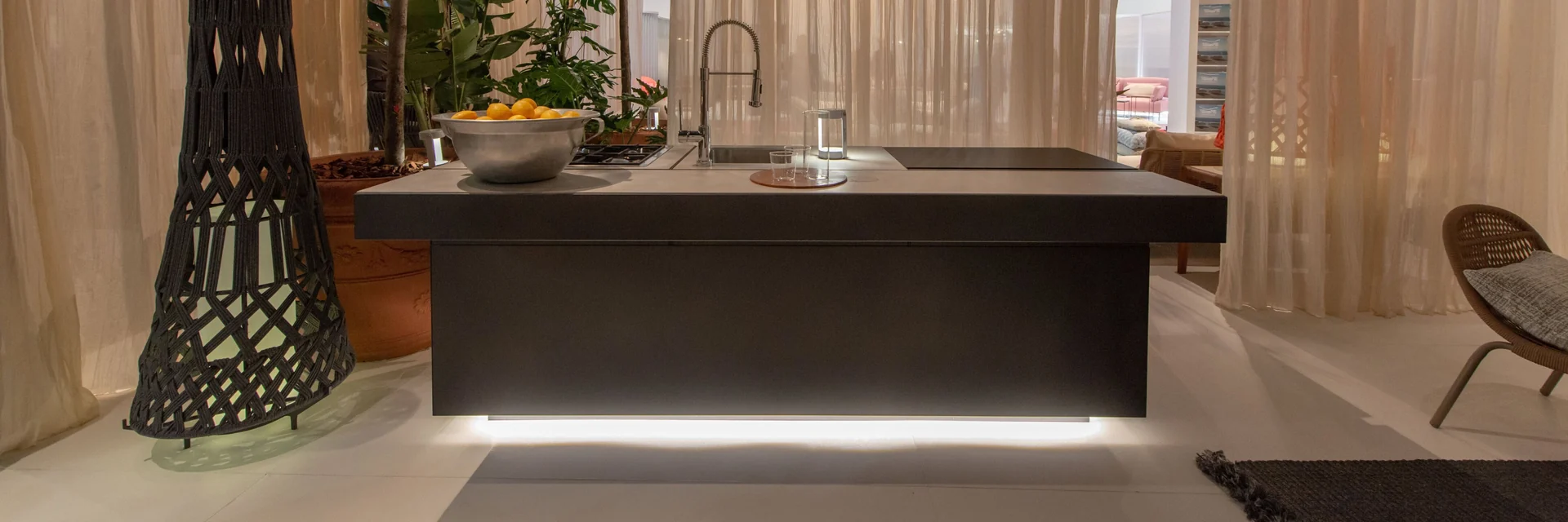 Dark Talenti Tikal outdoor kitchen island lit from below, in a room with sheer curtains