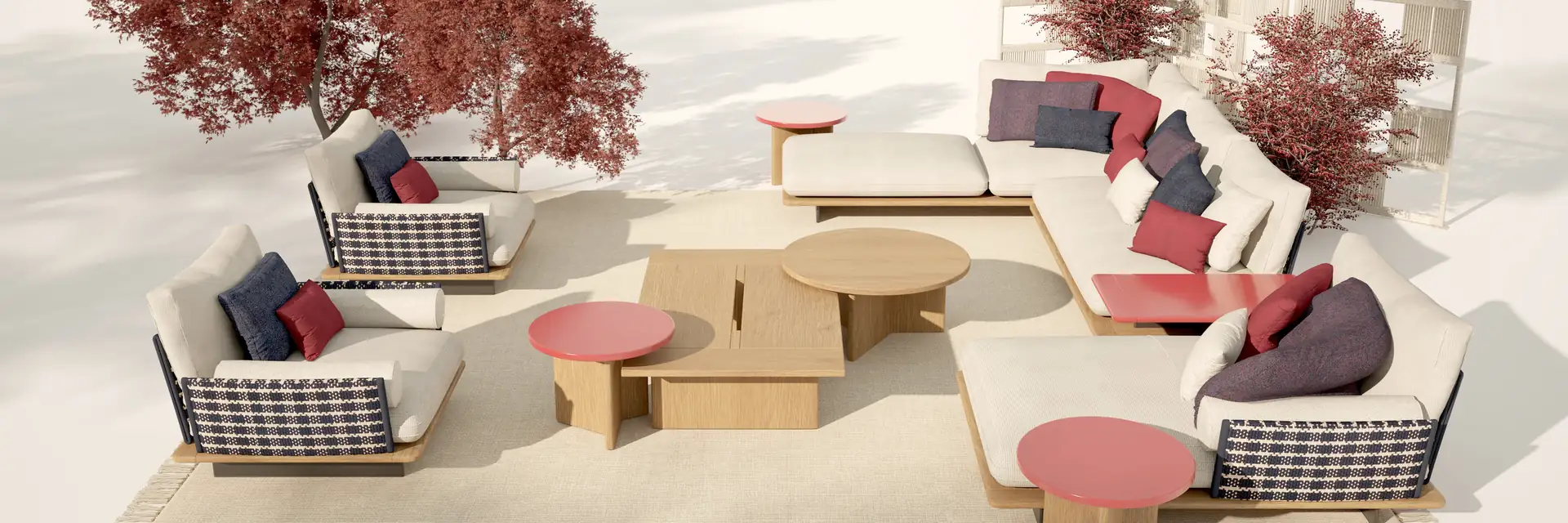 Talenti Venice sofas, armchairs and round low tables arranged in a pale set with red-leaved trees