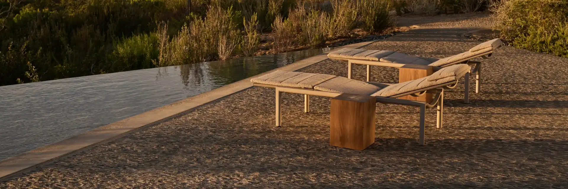Tribù Illum teak sun loungers beside a narrow pool at dusk, with an umbrella pine on the horizon