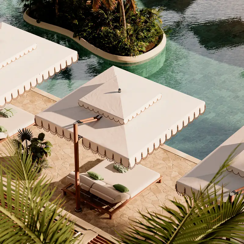 Tuuci Ocean Master MAX Cupola Cantilever parasol seen from above, its two-tier cream canopy with a scalloped valance shading a double sun lounger on a stone terrace beside a lagoon-style pool