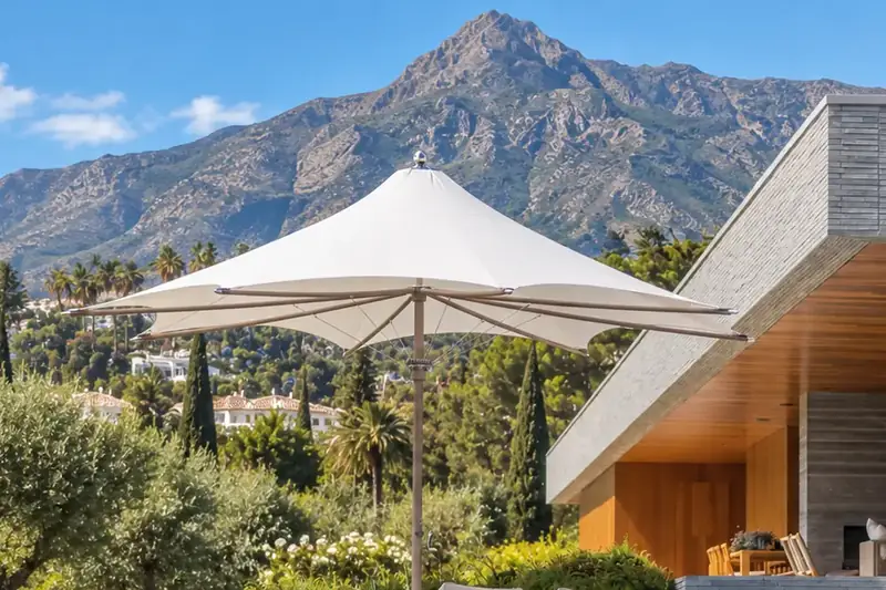 White Tuuci Ocean Master MAX F1 parasol beside the infinity pool of a modern villa, with La Concha mountain behind