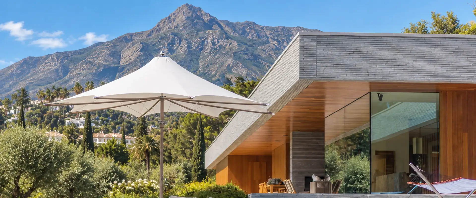 White Tuuci Ocean Master MAX F1 parasol beside the infinity pool of a modern villa, with La Concha mountain behind