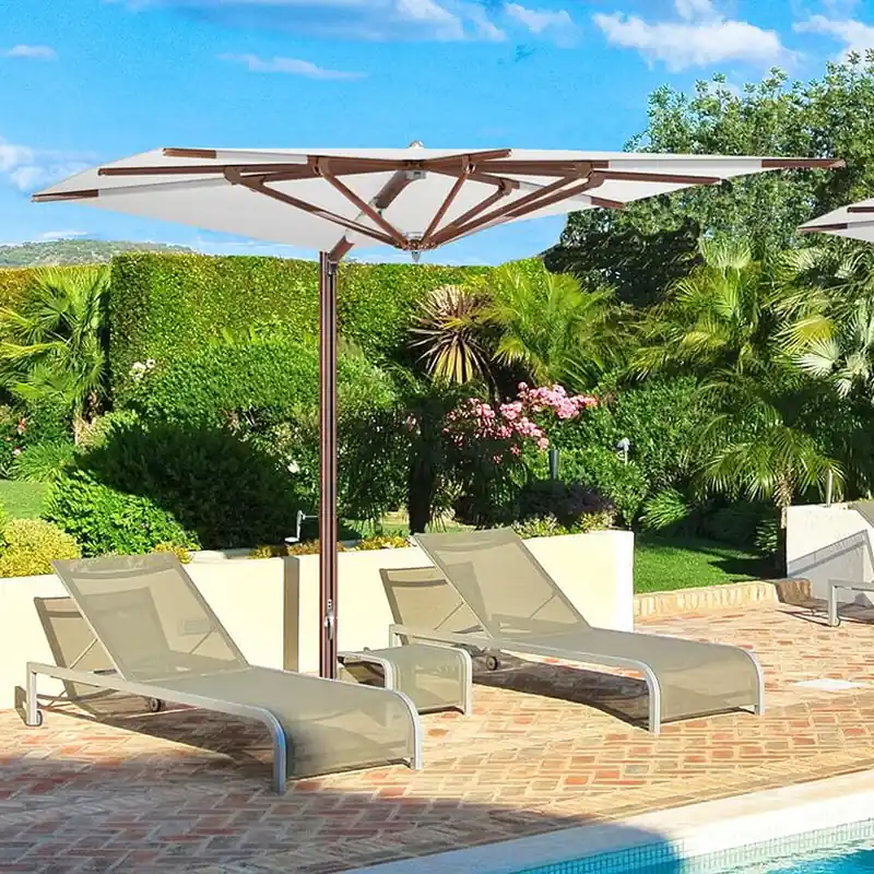 Tuuci Ocean Master MAX Zero Horizon Cantilever parasol with a flat white canopy and wood-finish frame over two sun loungers on a terracotta pool terrace, with a clipped hedge and palms behind