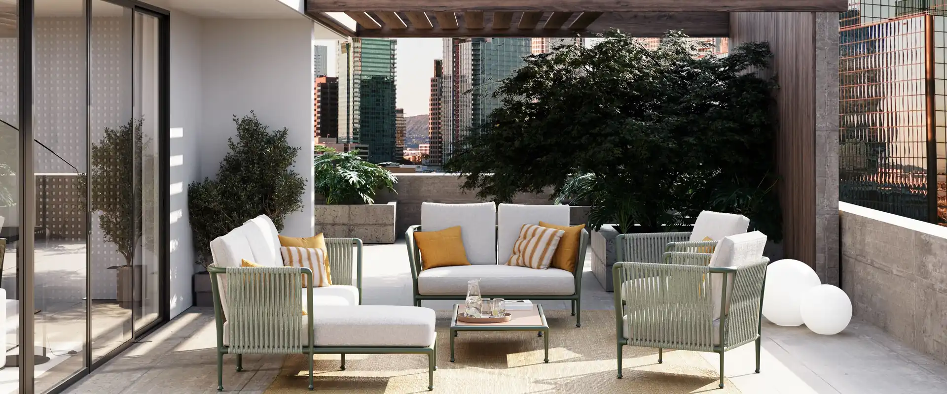 Unopiù Treble sofas and armchairs with rope-woven sides and pale cushions on the terrace of a modern house with a pergola