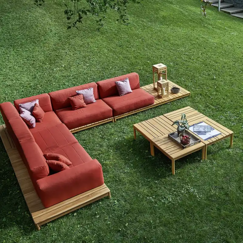 Varaschin Barcode L-shaped sectional sofa in red with a teak coffee table on a green lawn, seen from above