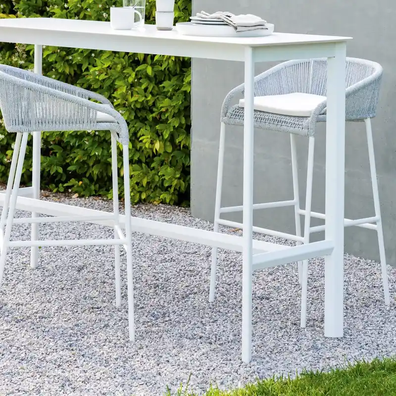 Two Varaschin Cricket white rope stools with backs at a white high table on a gravel terrace